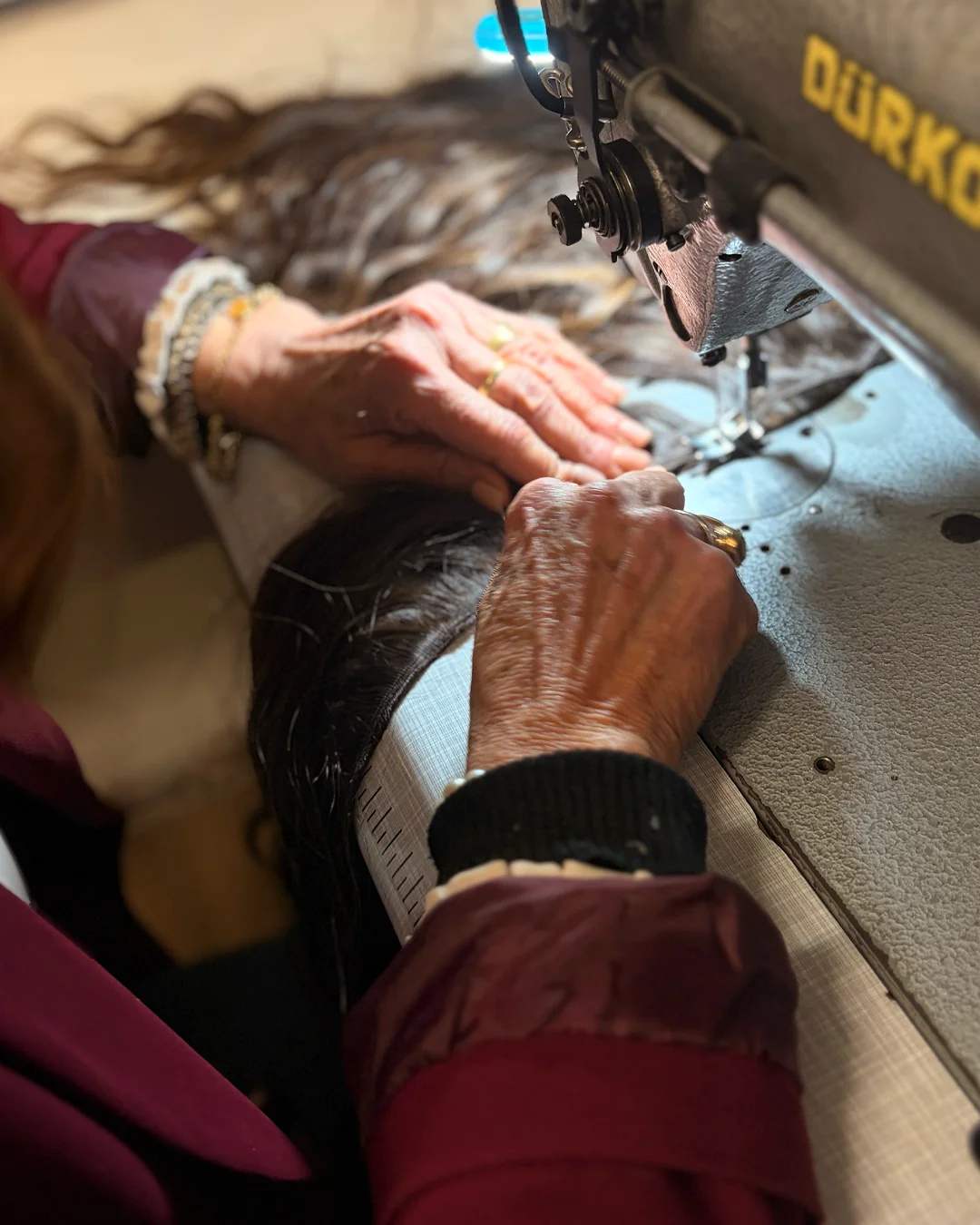 Mani al lavoro su una parrucca realizzata in laboratorio